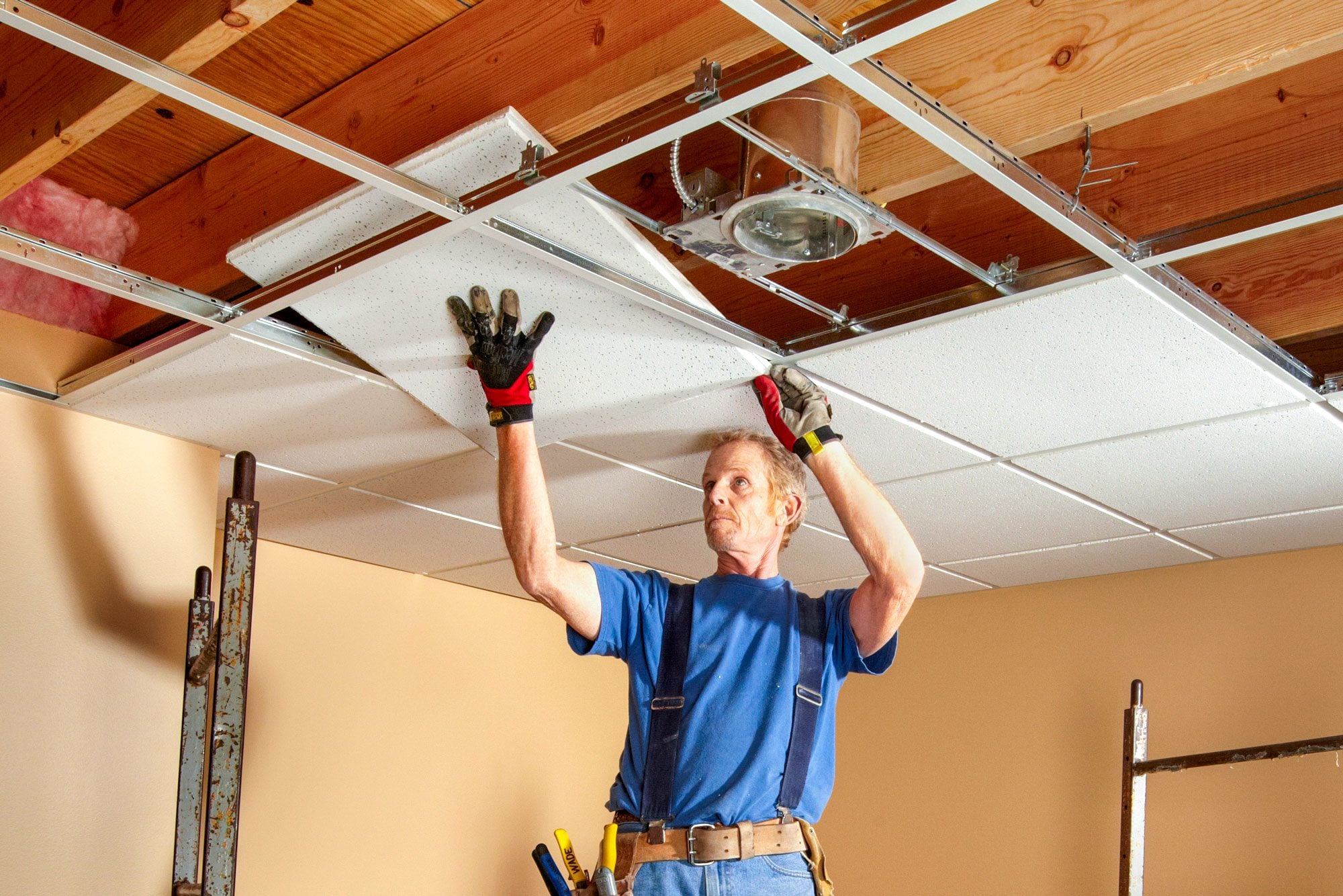 Professional installing suspended drop ceiling panels