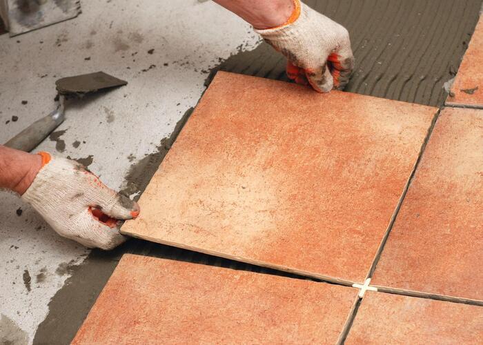 Professional placing terracotta ceramic floor tiles