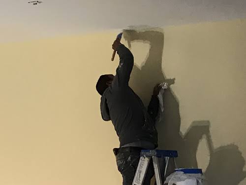 Professional spray painting interior wall with even coverage